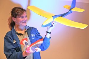 Junge Frau mit Vogel und Flugzeug in der Hand