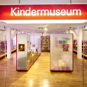 Blick ins Kindermuseum. Zu sehen sind Vitrinen mit Spielzeug.