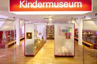 Blick ins Kindermuseum. Zu sehen sind Vitrinen mit Spielzeug.