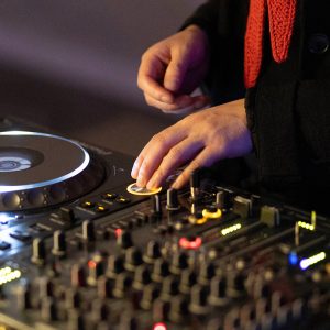 Zwei Hände, die an DJ-Turntables liegen