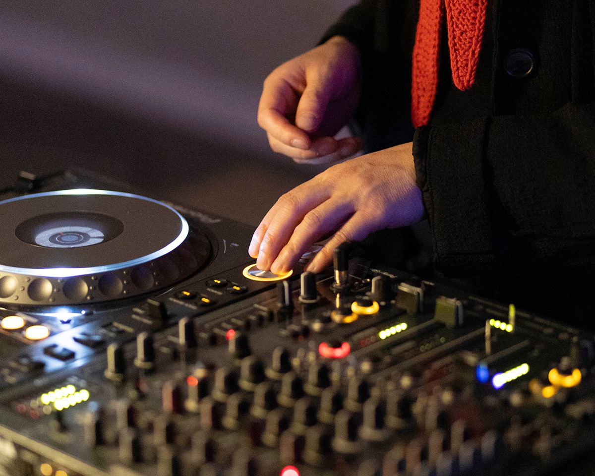 Zwei Hände, die an DJ-Turntables liegen