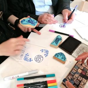 Blick auf einen Arbeitstisch mit Stempeln und Stiften.